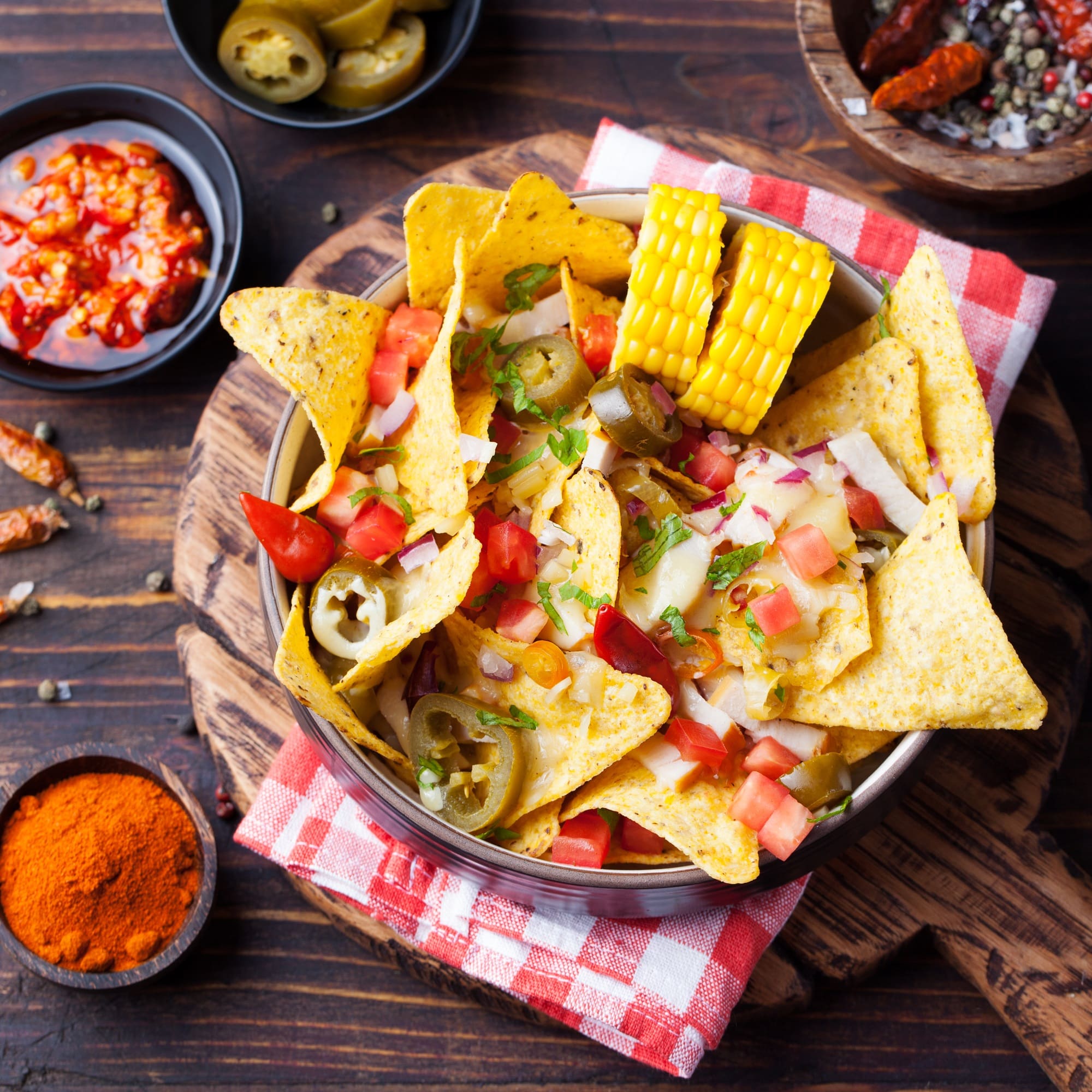 Nachos, cheese sauce, salsa and corn cobs Top view